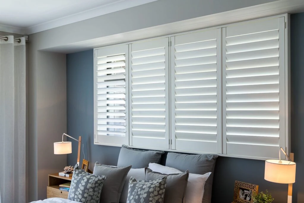 Bedroom with white plantation shutters installed