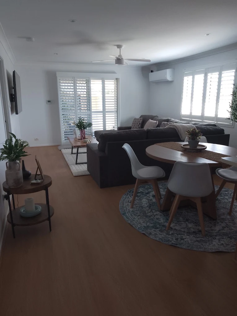Living and dining area with white plantation shutters
