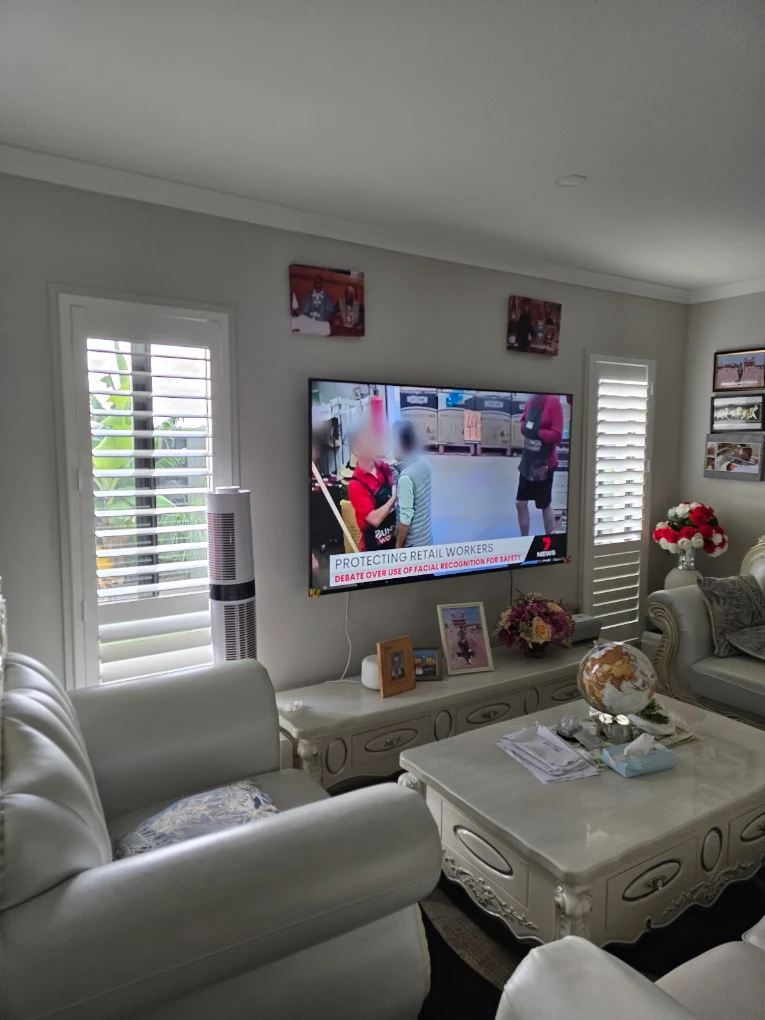 White plantation shutters flanking a TV in a living room